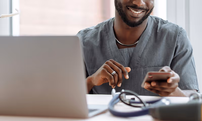 doctor-man-smiling-phone-laptop-strive-nav-dashboard